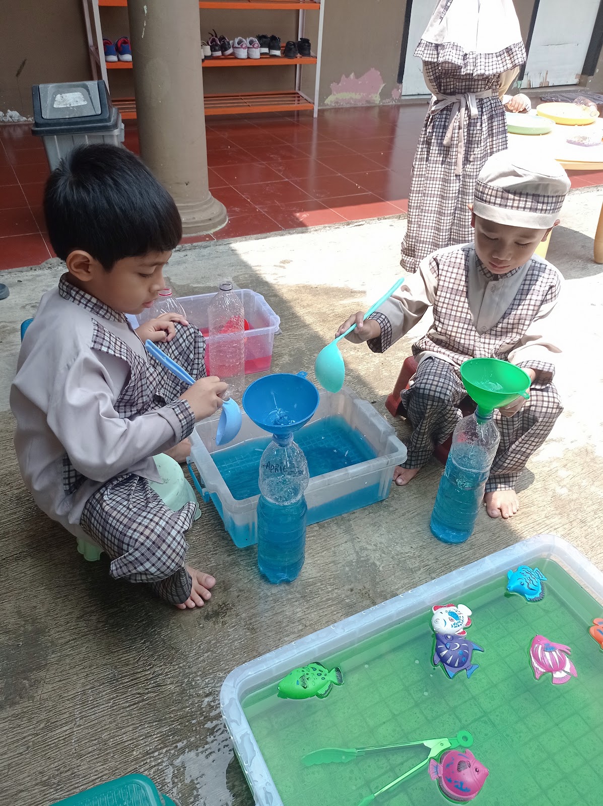 Anak menuang air dengan corong