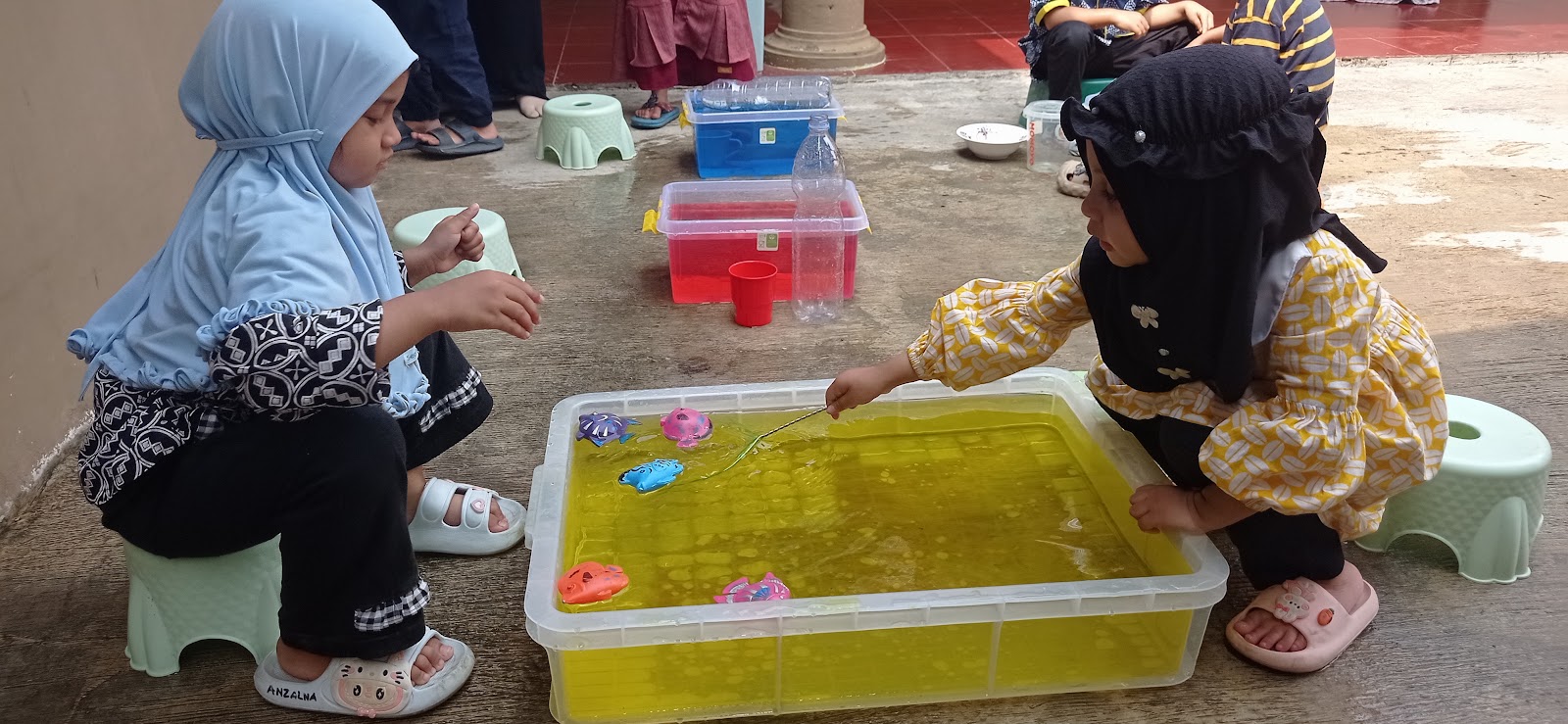 Bak air dan bahan main yang disiapkan guru untuk anak